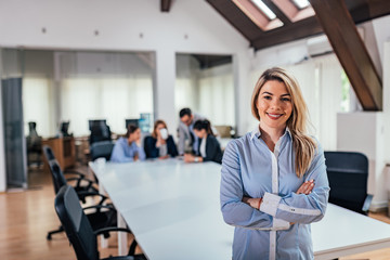 Wall Mural - Business leader in office with team colleagues at background.