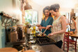 © jackfrog - Mixed group of friends have fun while cooking a meal in kitchen