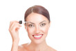 Woman applying serum essence essential oils to her eyebrows