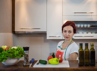 Young girl in the kitchen, smile on the face, cooking lunch, various vegetables in preparation, lettuce, broccoli, kitchen, girl in the kitchen, cassia vegetables