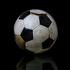 Wall Mural - Old Soccer ball on black background