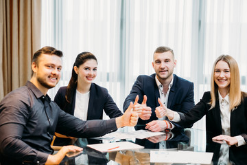 Wall Mural - success and financial achievement concept. confident business men and women giving thumbs up.