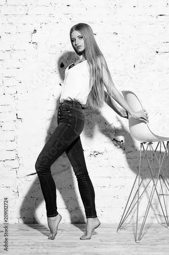 Young Beautiful Woman With Long Straight Blonde Hair In Blue Jeans