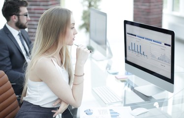 Wall Mural - young business woman sitting at the desk together with a colleague.