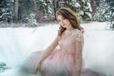 Fototapeta Do akwarium - Girl in a beautiful pink dress in a winter forest