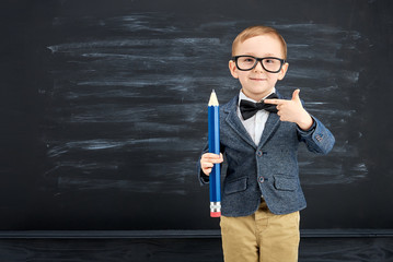 Little boy against blackboard. School concept