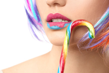 Sticker - Beautiful young woman with creative makeup and candy cane on white background, closeup