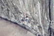© R - Male climber hanging on a safety rope on a cliff
