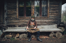 Old Bearded Forester With Axe Near Wooden Hut