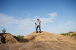 © snedorez - Photo from afar of tourist man with walking sticks on mountain hill