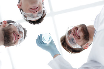 Wall Mural - closeup.a group of scientists looks at the liquid in the beaker
