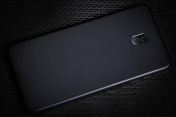 Black smartphone on background metal 