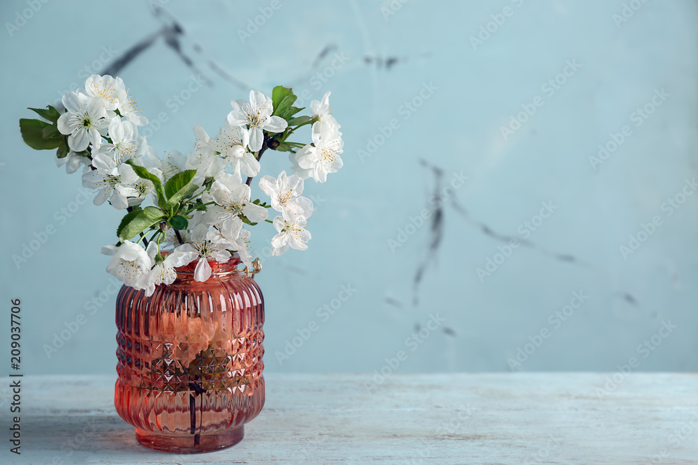 Vase with beautiful blossoming branches on wooden table