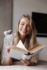 Poster - Smiling young woman holding blank cover open book