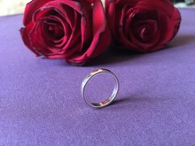 Two Red Roses With Engagement Ring On Purple Background