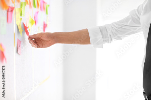 Cuadros en Lienzo Man with sticker near scrum task board in office