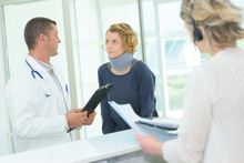 Woman Wearing Neck Support At Hospital Reception Desk