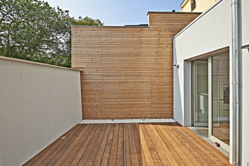 Wall construction with insulating wood cladding