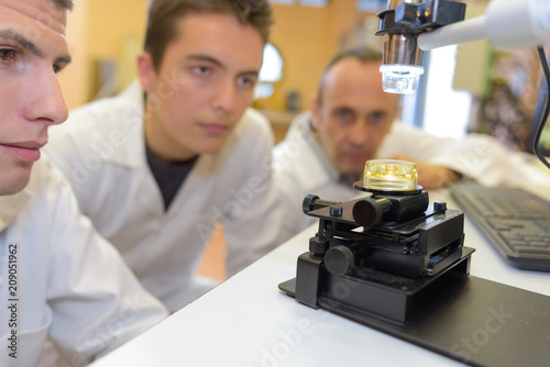 Fotografie, Obraz Students performing experiment with microscope