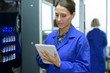 © auremar - technician holding digital tablet while examining server in server room