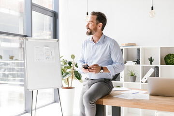 Wall Mural - Confident businessman using mobile phone