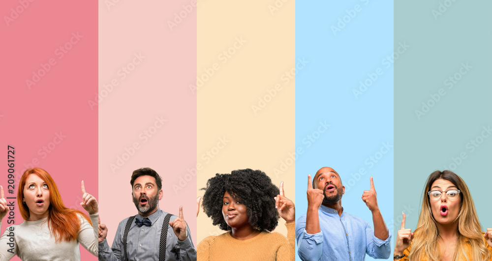 Cool group of people, woman and man happy and surprised cheering expressing wow gesture pointing up - obrazy, fototapety, plakaty 