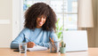 © Krakenimages.com - African american woman studying at home using a computer laptop with a happy face standing and smiling with a confident smile showing teeth
