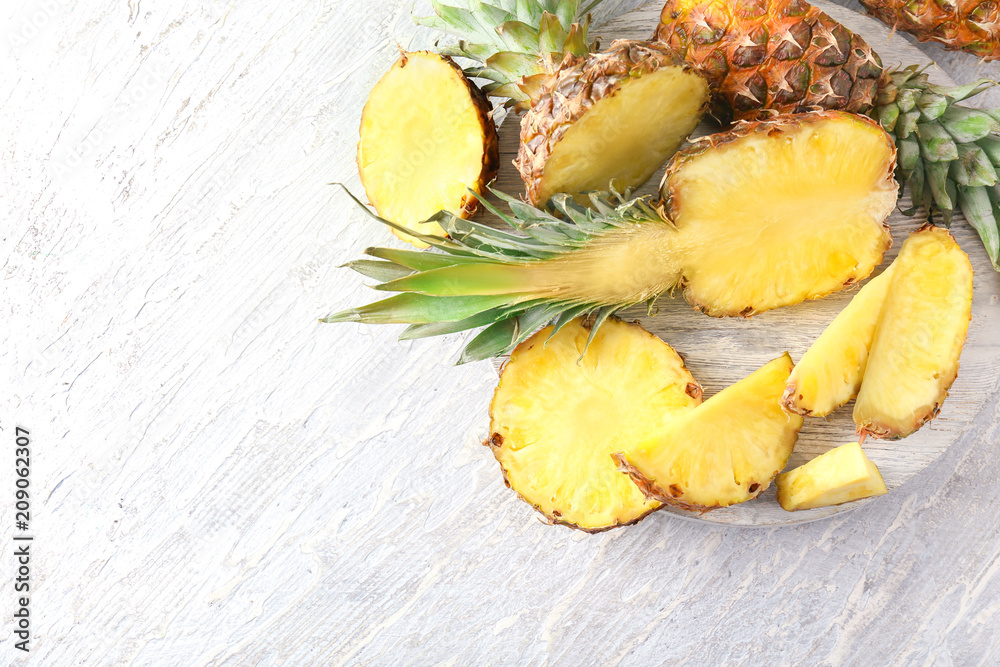Stand with delicious pineapples on wooden background