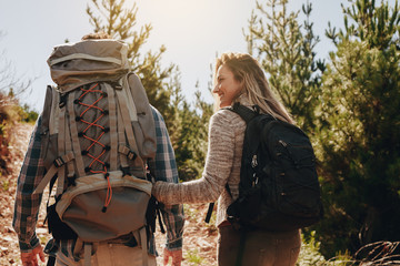 Wall Mural - couple with backpacks hiking on mountain