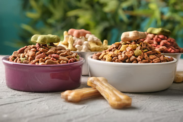 Bowls with pet food on table