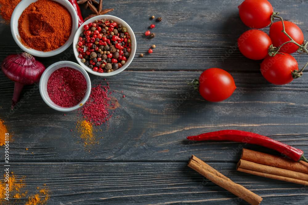 Bowls with various spices on wooden background