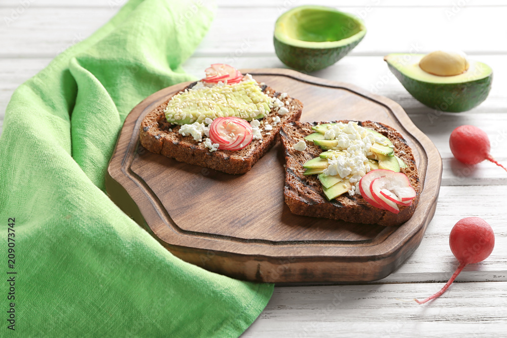 Board with tasty toasts on wooden background