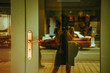 © Iuliia - Young woman holding camera and taking photo of herself in the door windows reflection. Solo woman traveler. Vintage tone filter effect
