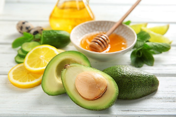 Avocado with ingredients for natural homemade cosmetics on wooden table