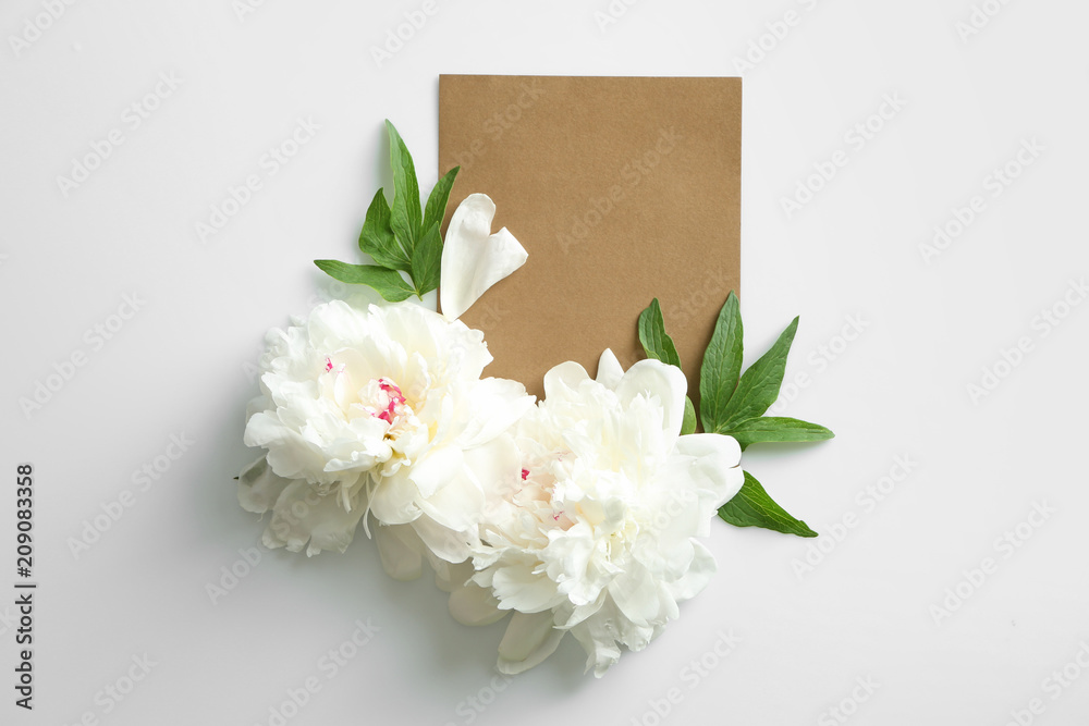 Beautiful peony flowers with blank card on white background