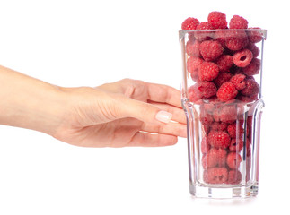 Canvas Print - A glass of raspberries in a hand on a white background isolation