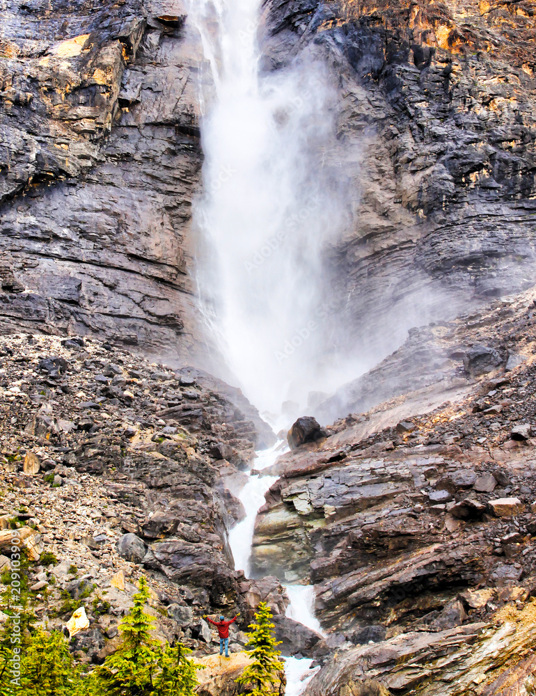 Man Standing in Awe at Base of Powerful Roaring Waterfall Stock Photo ...