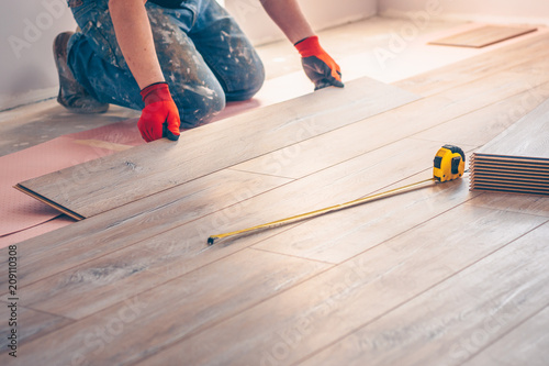 Fotografía Working with hands installs a laminate board, professional flooring installation