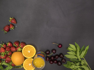 Wall Mural - flat lay of fresh healthy food with mint cherry and orange juice copy space on blackboard