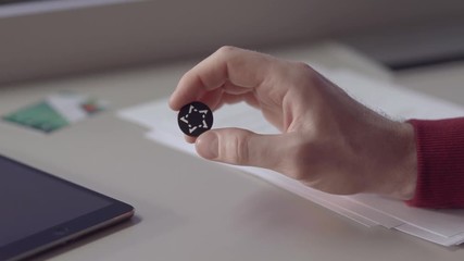 Aufkleber - Men hold coin. Stock. Hand holding black coin close-up. Blockchain investment concept