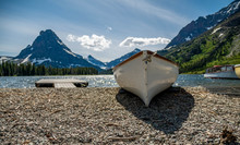 A Row Boat Sits On The Shore At Lower Medicine Lake In Aster Park Inside Glacier National Park, Montana