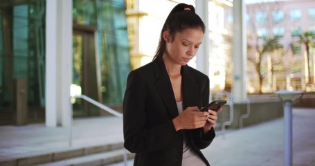 Wall Mural - Pretty business woman downtown texting on smart phone, Successful female in wearing blazer using 4g mobile device, 4k