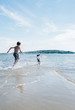 © Cara Dolan/Stocksy - Boy and his dog run into the ocean together