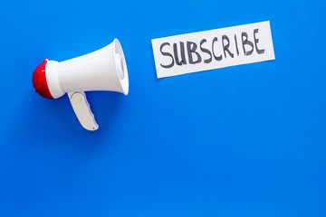 Poster - Subscribe template or mockup. Hand lettering subcribe near megaphone on blue background top view space for text