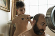 © Beatrix Boros/Stocksy - Son cutting his father's hair