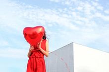 Anonymous Female Model With Red Heart Ballon Outside On A Sunny Day