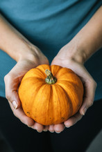 Young Woman Holding A Pumpkin In Hands