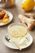 © Martisans/Stocksy - Glass of tea made of lemon, honeycomb and ginger root on table.