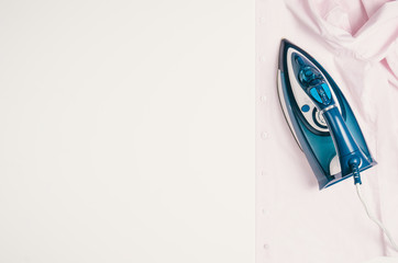 Wall Mural - Ironing clothes top view isolated on white background. Ironing shirt seen from above during housework. Violet or pink iron isolated on white table.