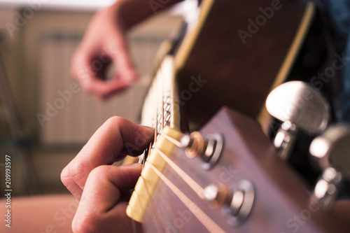 Fotografie, Obraz Female hand playing on acoustic guitar. Close-up.
